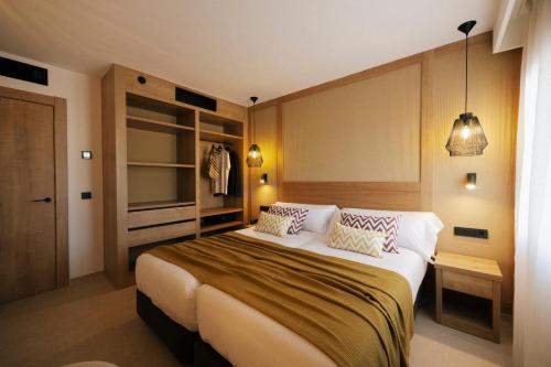 a bedroom with a large bed with two pillows at Caramelo Marina Calan Bosch - Adults Only in Cala en Bosc