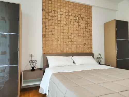 a bedroom with a large bed and a brick wall at Bastia Home Plus in Bastia Umbra