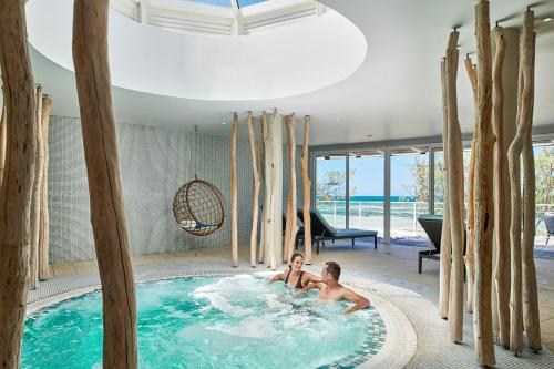 two people in a hot tub in a house at Le Méridien Nouméa Resort & Spa in Noumea