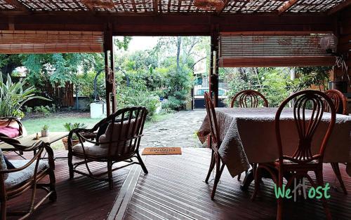 une table et des chaises sur une terrasse en bois dans l'établissement La Casa Inès Creole charm direct lagoon access, à La Celle-sous-Gouzon