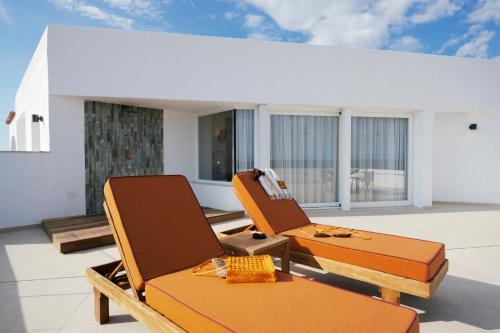 two chairs sitting on top of a balcony at Caramelo Marina Calan Bosch - Adults Only in Cala en Bosc