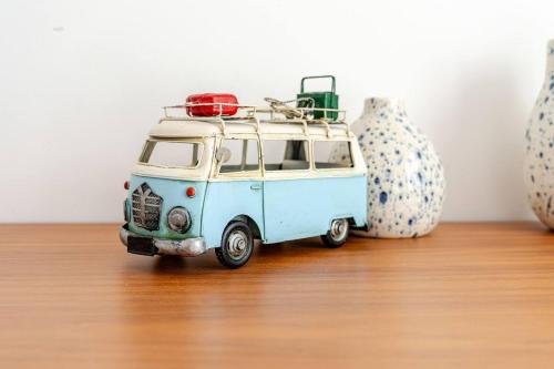 a small blue and white van toy on a wooden floor at Bica Vista in Lourinhã