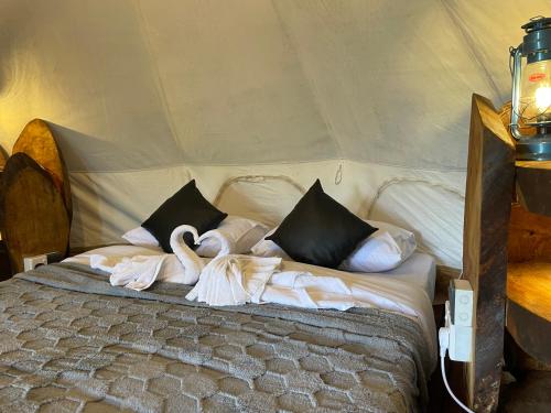 a bed in a tent with swans on it at Ella Heaven View Glamping Tent in Nikawatawana