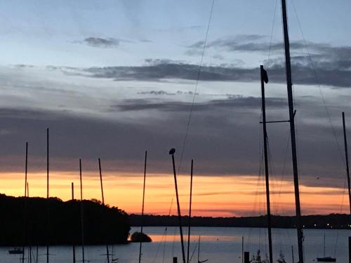a group of boats in the water at sunset at Chalet en pleine nature - le "Clos des Chevreuils" in Barbençon