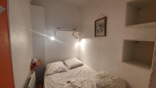 Cette petite chambre blanche comprend 2 lits. dans l'établissement Appartement rénové en plein coeur de Cauterets, à Cauterets