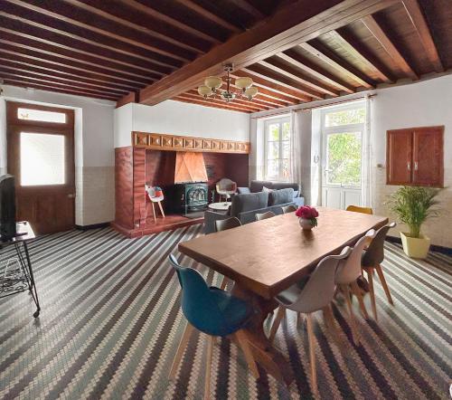 un salon avec une table et des chaises en bois dans l'établissement Séjour champêtre à la ferme près de Pau, à La Celle-sous-Gouzon