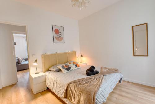 - un ours en peluche assis sur un lit dans une chambre dans l'établissement *Appartement Moderne/2 minutes du métro*, à Saint-Ouen