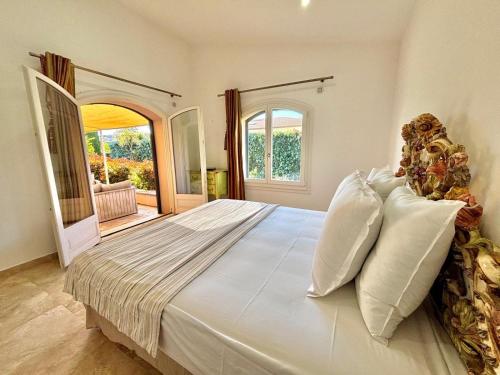 - une grande chambre avec un grand lit et des oreillers blancs dans l'établissement fontanella, à Sainte-Maxime