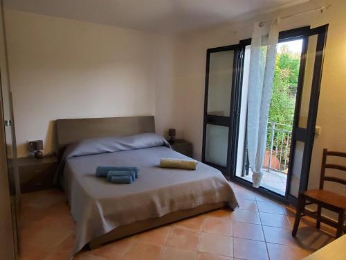 ブドーニにあるCasa vacanze in budoni San lorenzoのベッドと大きな窓のある寝室