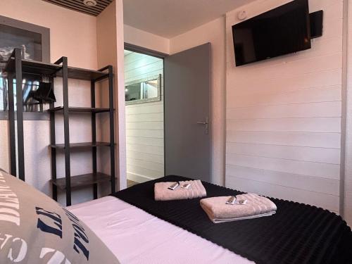 a bedroom with a bed with two towels on it at Hôtel et Appart 'hôtel Chez Gino ETAPLES-Le Touquet in Étaples