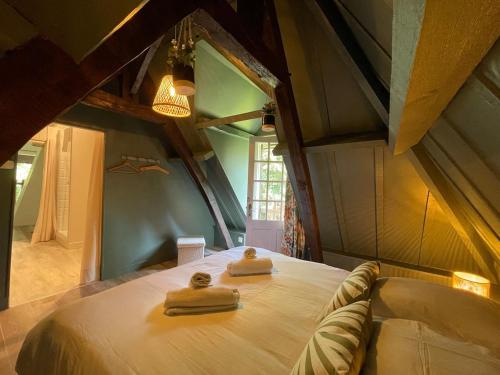 une chambre avec un lit avec deux serviettes dessus dans l'établissement LA SELLERIE Charmante maison de campagne au milieu d'une ile, à Canehan