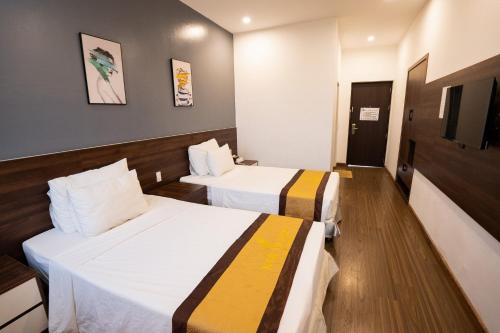 a hotel room with two beds in a room at Kim Thanh Hotel, Vinh Phuc - Near Heron Lake Golf, Dam Vac in Vĩnh Phúc