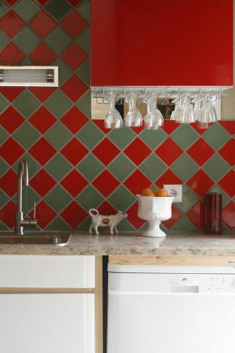 a kitchen with red and green tiled wall at Sonho do Poeta in Sintra