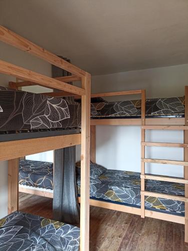 une chambre avec trois lits superposés dans une pièce dans l'établissement Gite d'étape, à Osmanville