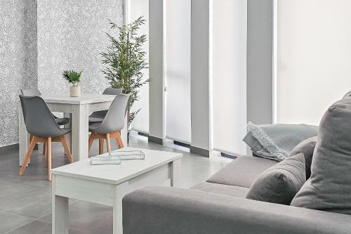 a living room with a couch and a table at Ro's Lil Suites San Juan Alicante in Alicante
