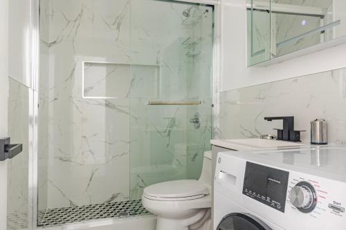 a bathroom with a toilet and a glass shower at Blueground Midtown West wd nr Broadway NYC-1863 in New York