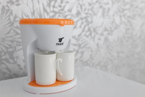 a coffee maker with two cups on a shelf at Ro's Lil Suites San Juan Alicante in Alicante
