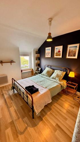 a bedroom with a bed and a wooden floor at Montoir-de-Bretagne in Montoir-de-Bretagne