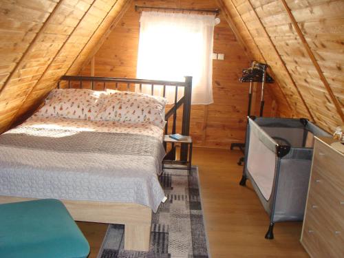 Un dormitorio con una cama en una cabaña de madera. en Domki u Uli, en Jarosławiec