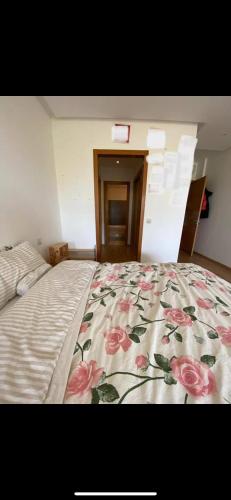 une chambre avec un lit avec une couette fleurie dans l'établissement Appartement cosy, à Perpignan
