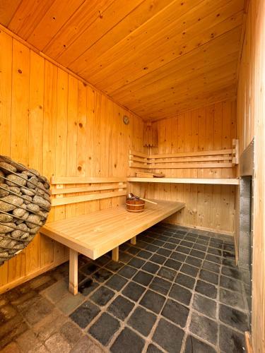 eine Holzsauna mit einer Bank in der Mitte in der Unterkunft Wellness Tuin - Boudoir Suite - Ultieme Partner Beleving - Indoor Jacuzzi en Openhaard en privé Sauna - in Romantische stijl - Gratis Fles Prosecco & Leuke Partner connect box ! in Horst