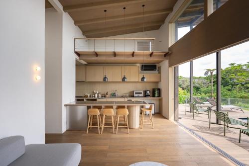 a kitchen with a counter and stools in a house at Dei Amami in Amami