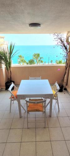 une table et des chaises dans une pièce avec vue sur l'océan dans l'établissement Theo'z apartments, à Cannes