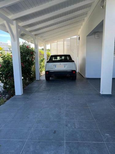 une voiture blanche garée sous un parking couvert dans l'établissement Villa MangoKera, à Saint-François