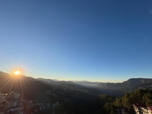 a view of the sun setting on a mountain at Tanwar B&B (bloominn) in Shimla