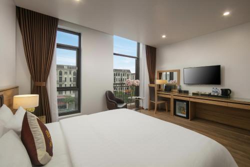 a hotel room with a bed and a television at Lam Anh Hotel 5 Him Lam Vạn Phúc in Hà Ðông