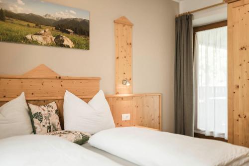 a bedroom with a bed with white sheets and pillows at Oberhuberhof in Rodengo