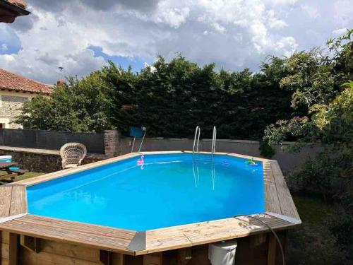 a swimming pool in a backyard with a wooden deck and a blue pool at Villa Doble M in Cervera de Pisuerga