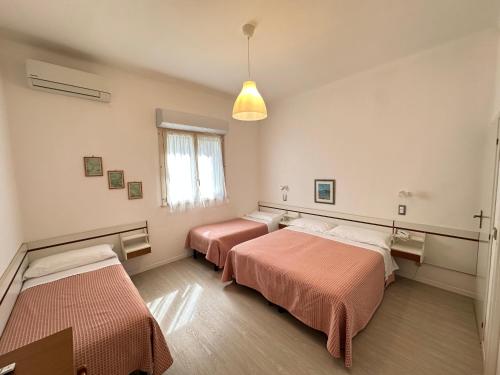 ein Zimmer mit 2 Betten und einer Hängeleuchte in der Unterkunft Hotel Fiorenza in Milano Marittima