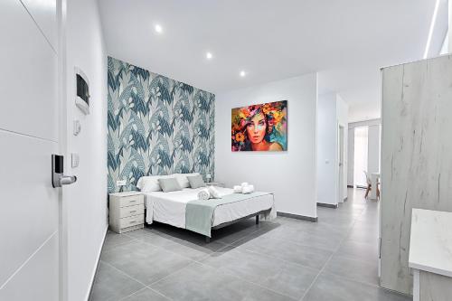 a bedroom with a bed and a painting on the wall at Ro's Lil Suites San Juan Alicante in Alicante