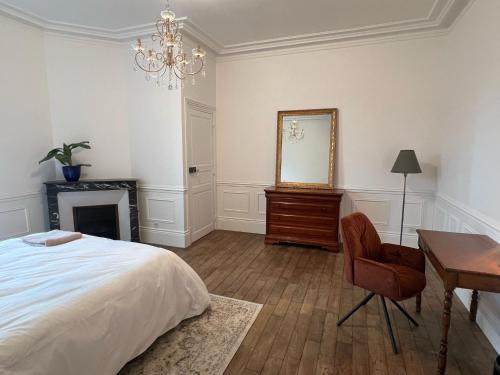 une chambre avec un lit, un bureau et un miroir dans l'établissement Suite privative au Domaine des Étoiles du Gâtinais, 