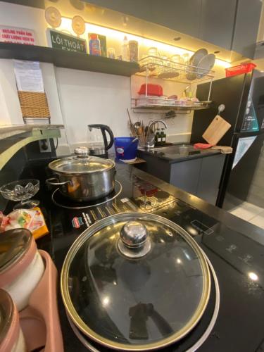 a kitchen with a stove with pots and pans on it at Le Sable Homestay in Vung Tau