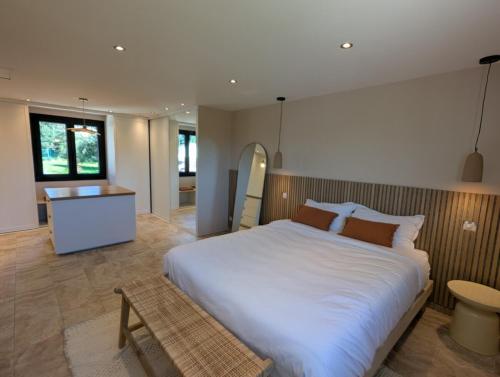 une chambre avec un grand lit blanc et une salle de bain dans l'établissement Villa Avanaelle, à Lambesc