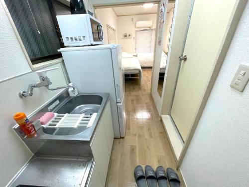 a small kitchen with a sink and a microwave at Gest house Near Disneyland in Tokyo