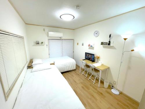 a bedroom with two beds and a desk with a desk at Gest house Near Disneyland in Tokyo