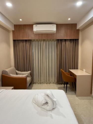 a hotel room with a bed with a towel on it at JRV Residence in Ambāsamudram