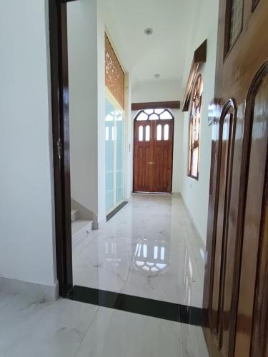 a hallway with a wooden door and a tile floor at KAPOOR SAHAB HOMESTAY COUNTRYSIDE Its a home away from home in Saraia