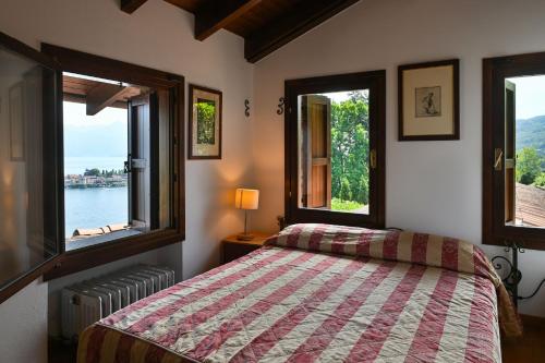 a bedroom with a bed and two windows at Villa Gia in Someraro