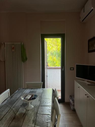 a living room with a wooden table and a window at Il Villotto in Monte SantʼAngelo