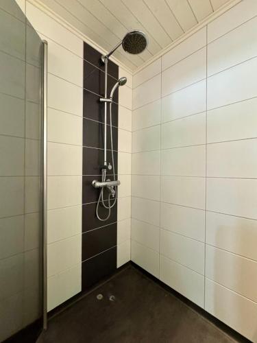 a bathroom with a shower with white tiles at Tullikatu Two-Bedroom Apartment in Kristinestad