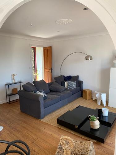 un salon avec un canapé bleu et une table dans l'établissement La Caussade - Charmant appartement dans villa Basque avec extérieur - Colline de Bordagain, à Socoa