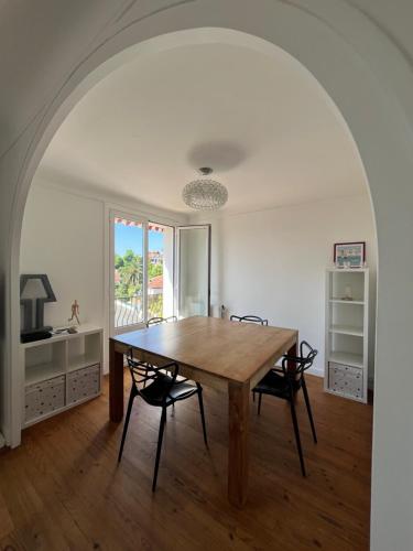 une salle à manger avec une table et des chaises en bois dans l'établissement La Caussade - Charmant appartement dans villa Basque avec extérieur - Colline de Bordagain, à Socoa