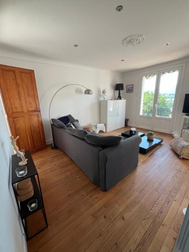 - un salon avec un canapé et du parquet dans l'établissement La Caussade - Charmant appartement dans villa Basque avec extérieur - Colline de Bordagain, à Socoa