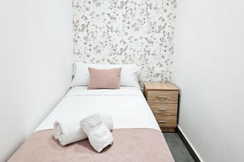 a small bedroom with a bed with two pillows at Ro's Lil Suites San Juan Alicante in Alicante