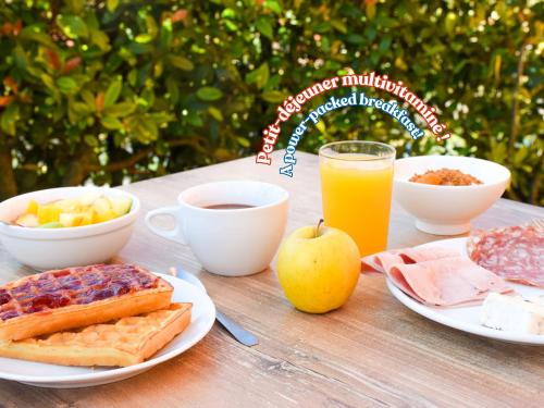 a table with breakfast foods and a glass of orange juice at ibis Budget Millau Viaduc in Millau