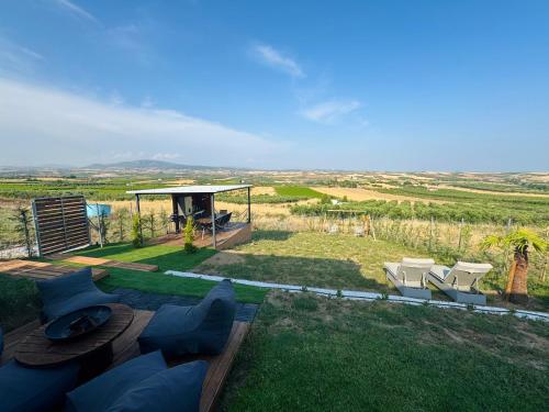 a garden with chairs and a gazebo with a view at Spemaré Residence Halkidiki in Nea Kalikratia